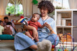 © Jovo Jovanovic/Stocksy - Caregiver holds baby, plays with toy in daycare setting.