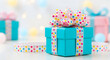 © Jack store - Bright turquoise gift box with multicolored polka dot ribbon on white surface