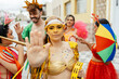 © kleberpicui - Woman raising her hand in a stop gesture to reject harassment during a Brazilian carnival street celebration, while friends support her around.