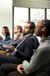© DC Studio - Male CEO in attendance asking questions during conference discussion, engaging in professional debate and listening to speech. Group of white collar workers attend international summit.