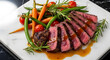 © MdZalal - A plate of sliced steak with vegetables and sauce on a white plate served on a table