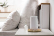© Pixel-Shot - Air humidifier with bottle of essential oil on bedside table in bedroom, closeup