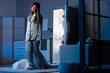 © Pixel-Shot - Female sleepwalker with blanket near fridge in kitchen at night