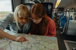 © bernardbodo - Two women examining a map on a train