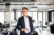 © Westend61 - Smiling mature businessman with coffee mug in office