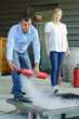 © auremar - team of coworkers using fire extinguisher