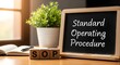 © Asad - Small chalkboard displays the meaning of sop standard operating procedure next to wooden blocks and an open notebook.