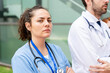 © StockMe - Focused healthcare team standing outdoors, female nurse and male doctor looking determined and dedicated to healthcare service
