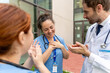 © StockMe - Healthcare team showing appreciation to a happy female nurse. Doctors and nurses celebrating achievement and teamwork outside a clinic