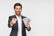 © InsideCreativeHouse - Successful businessman holding cash money pointing finger on you, isolated white background. Big luck, dollar cash money rejoices to win, lottery winner, big income wealth, investment concept.