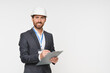 © InsideCreativeHouse - A cheerful male engineer wearing a safety helmet and business attire, holding a clipboard in a spacious and well-lit industrial facility, exuding professionalism and confidence.