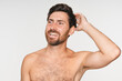 © InsideCreativeHouse - Pensive, handsome, sexy Caucasian man, fashion model with naked torso, touching head hair looking aside standing isolated on white background, copy space. Barbershop services, cosmetic for men ads