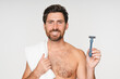 © InsideCreativeHouse - Smiling man face male model with razor in studio isolated on a white background. Epilation, cleaning and shirtless man with facial product, foam or gel to shave for wellness or hair removal