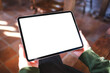 © Farknot Architect - Mockup image of a woman holding digital tablet with blank white desktop screen in cafe