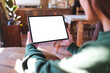© Farknot Architect - Mockup image of a woman holding digital tablet with blank white desktop screen in cafe