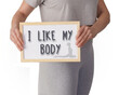 © Inspiraciones - I LIKE MY BODY. Woman in gray sportswear with the message written on a whiteboard
