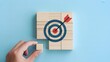 © OnlyDesign - Building blocks form a target with an arrow, symbolizing achieving goals and strategic planning.