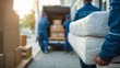 © KotBaton - Professional movers carrying a wrapped mattress to a delivery van. Home relocation, furniture transportation and moving service concept.