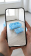 © Prabhash - Hands holding a smartphone displaying augmented reality furniture in an empty room for home interior design planning