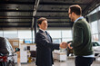 © Drazen - Happy car salesperson greeting his customer in showroom.