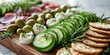 © MNStudio - Modern charcuterie board with cucumbers, goat cheese, olives and crackers, styled with artistic precision. Bright minimalist kitchen scene with realistic food styling and clean light.