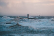 © Maria Sap - Red and white lighthouse in the middle of a stormy ocean with huge waves.