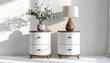 © CetakUndangan - Two white bedside tables with wooden accents, lamp, vase with flowers, and shadows