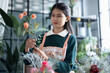 © Charlie's - Happy asian female florist Startup small business successful SME in flowers shop 