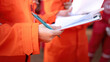 © Nattawit - Close-up at operation supervisor hand in action of checking on the document and certification during perform safety audit at construction working site. Industrial working scene.