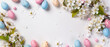 © pecherskiydotkz - Pastel speckled Easter eggs and delicate white blossoms frame a clean white background, creating a fresh, elegant spring holiday composition.