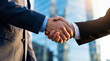 © Robert - Businessmen in dark suits shaking hands outside a modern skyscraper during daytime.