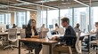 © CuteBee - A focused man and woman in glasses collaborate on their laptops at a table in a modern, bright office setting.