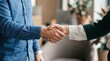 © BAYEZID - Closeup of two businessmen shaking hands in a modern office space with blurred background
