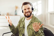 © Prostock-studio - Cheerful Male Freelancer Making Video Call Wearing Headset Smiling And Talking Looking At Camera Sitting In Chair At Home. Modern Distance Online Communication Concept