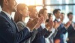 © NgocThanh - Diverse group of professionals applauding in a modern office setting during a presentation or event.