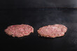 © meeboonstudio - Two beef burger patty cooking on black grill.