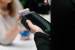 © Anton Pentegov - waitress holding in hands electronic cash register for contactless payment with paper receipt in cafe or restaurant, paying with smartphone, smart terminal concept