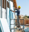 © picturehome - Worker Places Insulation Panels in Building Project