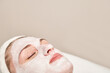 © elenavolf - Caucasian female adult relaxing with a facial mask for skincare and rejuvenation.