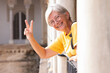 © luciano - Happy Caucasian senior tourist woman in yellow jersey and glasses visiting the Real palace Alcazar in Seville, Spain - travel vacation concept
