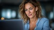 © Enigma - Young businesswoman smiling while working with a laptop, finding solutions for modern business and technology