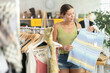 © JackF - Happy young woman choosing something for summer in clothing shop with large assortment