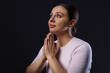 © New Africa - Religion. Christian woman praying on black background