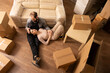 © DC Studio - Caucasian husband and wife sitting on floor surrounded by boxes, talking about new cozy home. Young spouses imagining happy moments and planning apartment decorations together.