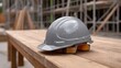 © Thares2020 - A protective grey hard hat rests on a wooden bench at a busy construction site