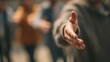 © Luminostock 54 - leadership  development nonprofits  volunteer concept. Close-up of an outstretched hand offering a handshake with blurred people in background