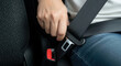 © Alina - Person fastening seat belt in car, safety and responsible driving in vehicle interior