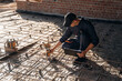 © standret - Sitting and using leveling tool. Builder is working on construction site, unfinished building