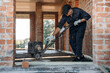 © standret - Process of leveling the concrete on the floor. Builder is working on construction site, unfinished building