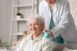 © Pixel-Shot - Senior woman and physical therapist massaging her shoulder with ball at home